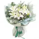 Bouquet of white lilies with eucalyptus and greenery, tied with a green ribbon.
