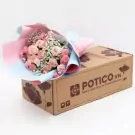 Pink and white rose and carnation bouquet on a cardboard box.