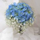 Bouquet of blue hydrangeas and baby's breath with white fabric.