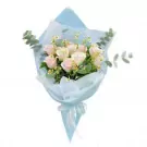 Bouquet of pink and white roses with small white flowers and green leaves, wrapped in light blue paper and tied with a white ribbon.