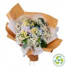 Bouquet of hydrangeas, daisies, and baby's breath wrapped in kraft paper with eco-friendly wrapping paper symbol.