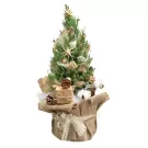 Small decorated pine tree with gold stars, pinecones, and gift boxes in burlap pot.