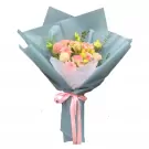 Bouquet of pink and white flowers wrapped in pale blue paper with pink ribbon.