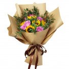A bouquet of sunflowers and purple roses wrapped in brown paper, tied with a brown ribbon.