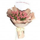 Pink tulip bouquet with a white banner and a yellow ribbon, on a white background.