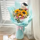 Graduation bouquet with sunflowers, pink carnations, baby's breath, and a graduation teddy bear.