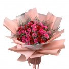 A bouquet of red and pink roses, wrapped in pink paper.