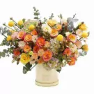 Floral arrangement of yellow and orange roses, hydrangeas, and spray chrysanthemums in a cream box.