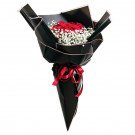 Bouquet of red roses and baby's breath wrapped in black paper, tied with a red ribbon.