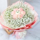 Bouquet of pink ping pong chrysanthemums and baby's breath with a cute smiley face decoration.