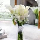 White calla lily and alstroemeria wedding bouquet tied with lace ribbon.