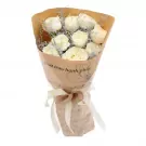 Bouquet of white roses with brown paper wrapping and white ribbon.