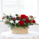 Basket of red roses, cotton, pinecones, and berries with eucalyptus and thistle.