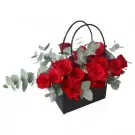 Black bag with red roses and eucalyptus.