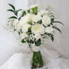 White bridal bouquet with roses, carnations, and baby's breath.