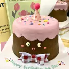 Cute chocolate cake with pink frosting, rosy cheeks, and a bow tie.