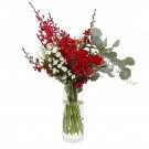 Vase of red and white flowers with green eucalyptus leaves.