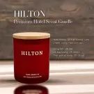 Hilton Premium Hotel Scent Candle in a red glass jar with a wooden lid.