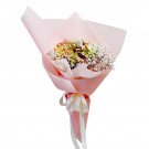 Pastel bouquet of hydrangeas and baby's breath in pink paper, tied with a ribbon.