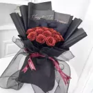 Sparkling ruby red roses bouquet wrapped in black paper and black mesh with Chanel ribbons.