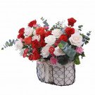 A basket of red and white roses with eucalyptus and pink carnations.