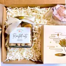 Gift box with jar of roasted nuts, lotus-themed box, and pink lotus-shaped item.