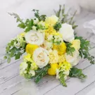 Yellow and white wedding bouquet with roses, snapdragons, and chrysanthemums.