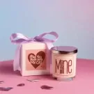 Gift box with purple ribbon and scented candle labeled "Mine".