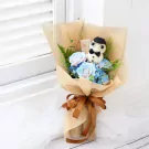 Bouquet with a teddy bear dressed as a teacher, surrounded by blue and pink roses and hydrangeas.