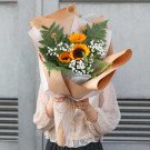 Bouquet of sunflowers, baby's breath, and greenery wrapped in brown and white paper.