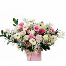 Pink floral arrangement in a box with roses, gerberas, and baby's breath.