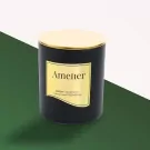 Black scented candle with gold lid and label saying "Amelier".
