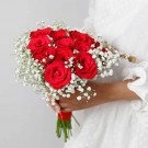Bridal bouquet of red roses and baby's breath with a red ribbon.