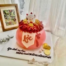 Pink lucky cat cake with gold coins and "Lộc" (prosperity) symbol.