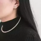 Woman wearing a high-quality pearl necklace and pearl stud earrings.