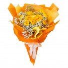 Bouquet of yellow roses, baby's breath, and orange paper, tied with a white ribbon.