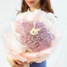 Bouquet of pink and purple baby's breath with a fuzzy bunny in the center.