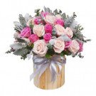 Round wooden box filled with pink and blush roses, accented with silver ribbon.