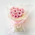 Pink gerbera daisy bouquet with sheer pink and yellow wrapping and ribbon.