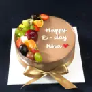 Chocolate mousse cake with fresh fruits and "Happy B-day Kha" written in white icing.
