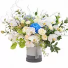 Elegant flower box with white orchids, roses, blue chrysanthemum, and greenery.
