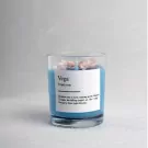 Blue scented candle in a glass jar with a label defining "Vega."