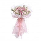 Pink and white rose bouquet with baby's breath, wrapped in white and pink paper with a pink ribbon.