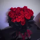 Bouquet of 30 red Ecuador roses wrapped in black paper with red ribbon.