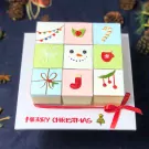Christmas mousse cake set with festive decorations on top and "Merry Christmas" text.