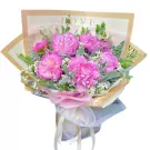 Bouquet of pink peonies, baby's breath, and greenery with "LOVE" text on wrapping.