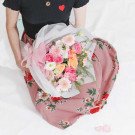 A person holding a bouquet of pink and orange flowers.