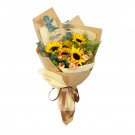 Bouquet of sunflowers, carnations, and eucalyptus wrapped in brown and cream paper, tied with a ribbon.