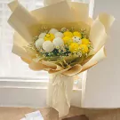 Yellow and white ping pong mum bouquet with daisy-like flowers.