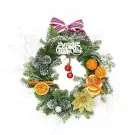 Christmas wreath with pine cones, dried oranges, cinnamon sticks, and a "Merry Christmas" sign.